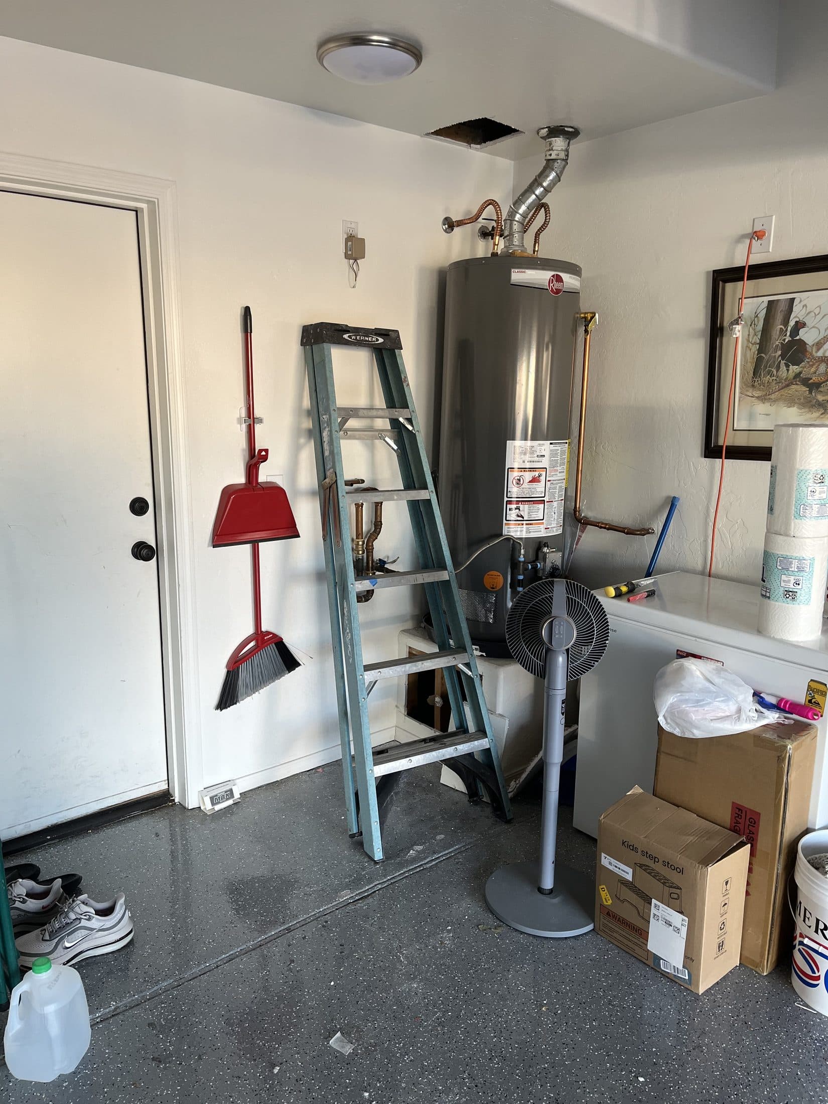 Gas water heater in a Mesa garage with new copper reroute piping run down the wall and up through the ceiling